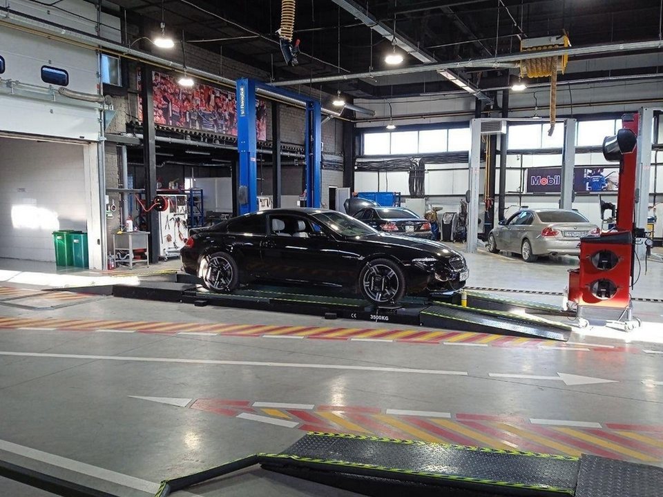 Автомобиль на подъёмнике стенда углов установки колёс