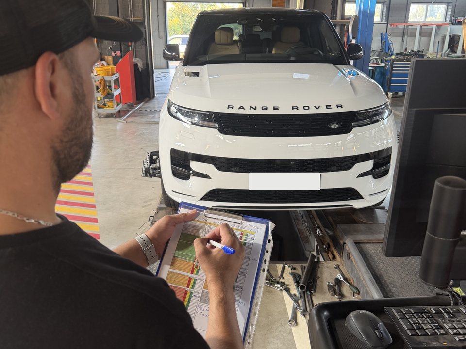 Мастер Tez Auto заполняет карту диагностики у машины на посту